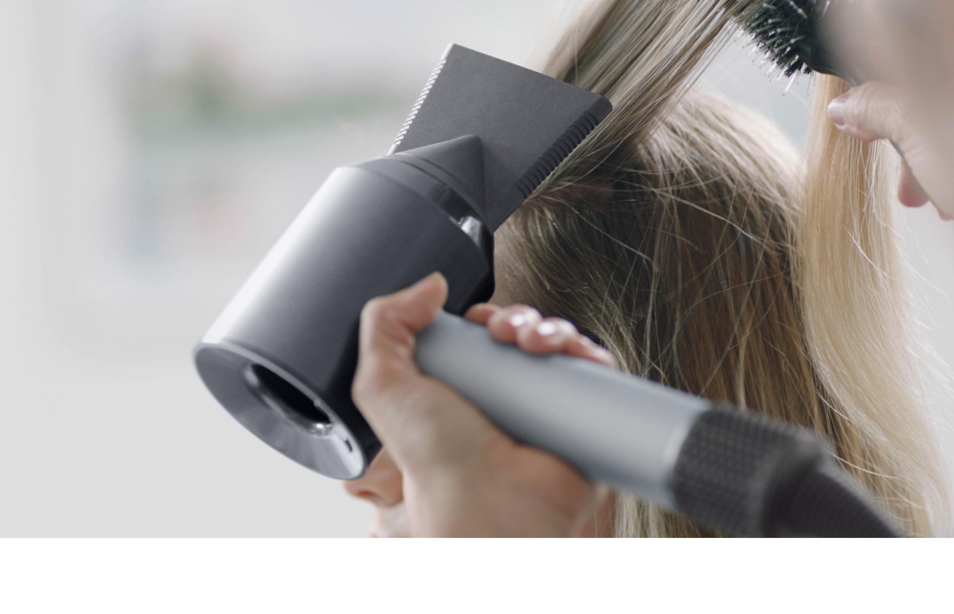 Stylist using Dyson Supersonic hairdryer for heat protection at Team Salon VivoCity eco hair salon